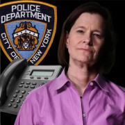Woman with dark hair in front of business telephone and an NYPD seal